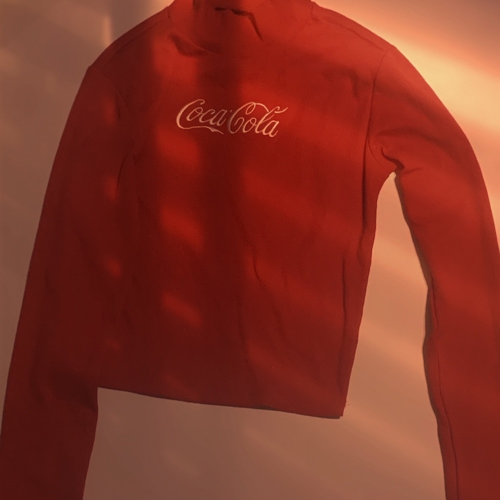 A crew neck with the coca cola logo on it